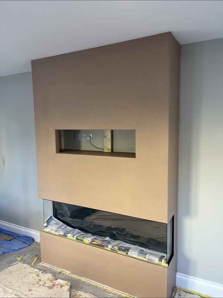 Fresh plaster finish around a built-in fireplace